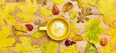 Kuru yapraklı çelenk çerçeveli sonbahar düz kompozisyonu ve ahşap bir arka planda boş kupa. 