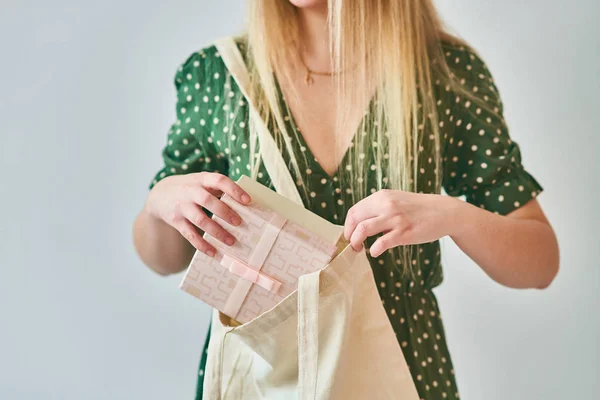 Молода жінка бере подарункову коробку з сумки . — стокове фото