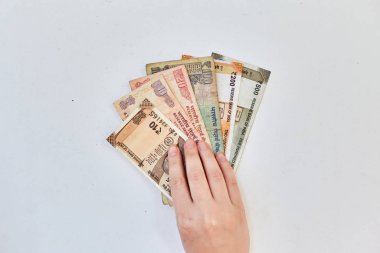 Kız 10, 20, 100, 500 'lük banknotlar halinde Hint rupileri tutuyor. Beyaz arka planda Hintli parası.