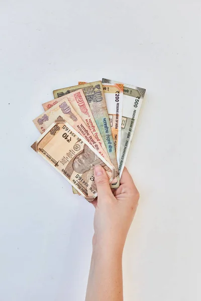 Το κορίτσι έχει ινδικές ρουπίες σε αξίες των 10, 20, 100, 500. Ινδικά χρήματα σε λευκό φόντο. — Φωτογραφία Αρχείου
