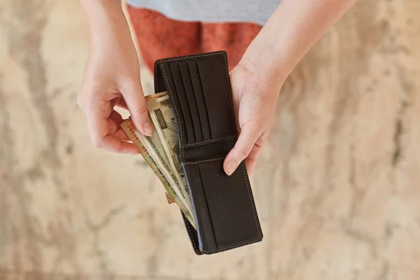 Indian rupees in a wallet. The wallet in the hands of a girl with Indian rupees