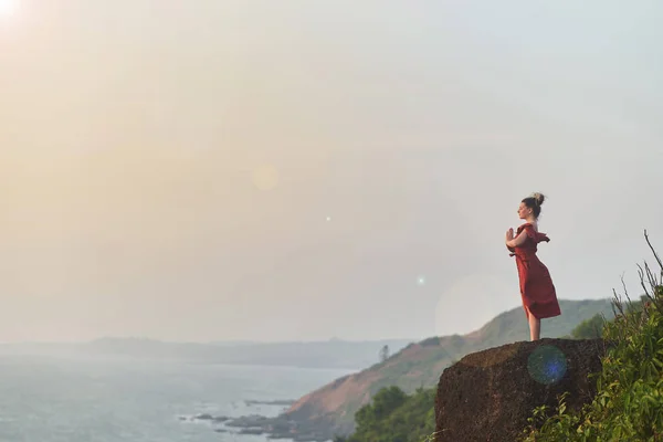 Chica joven practica yoga en un vestido rojo en una montaña en la India — Foto de Stock