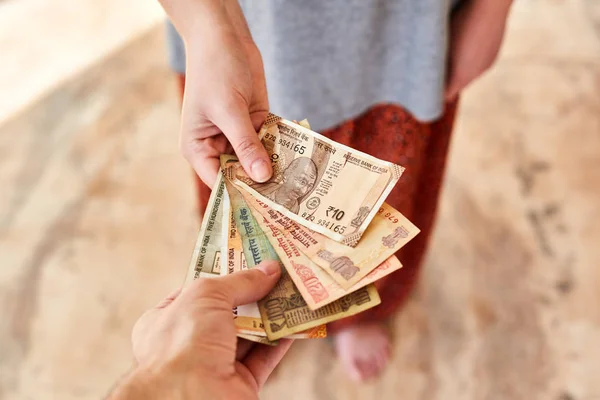 A young girl pays Indian rupees. The girl pays the man. — Stock Photo, Image