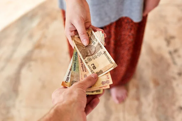 Ένα νεαρό κορίτσι πληρώνει ινδικές ρουπίες. Το κορίτσι πληρώνει τον άντρα.. — Φωτογραφία Αρχείου