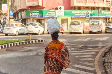 Panaji, Goa, Hindistan - 15 Aralık 2019: Goa Panaji 'nin eyalet başkentinin sokakları. Kafasında plastik torba taşıyan bir kadın.