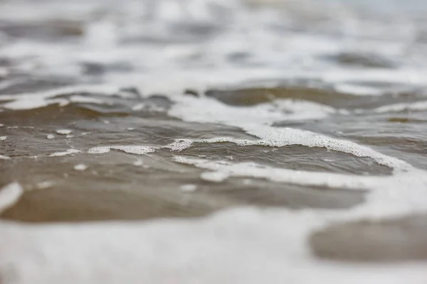Skum på havsvatten. Närbild av vatten. — Stockfoto