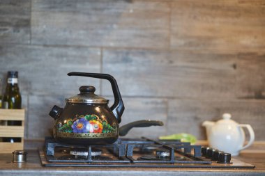 Gaz ocağında resmi olan demir çaydanlık..