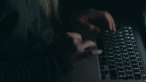 Overhead hacker in the hood working with laptop typing text in the darkroom. — Stock Video