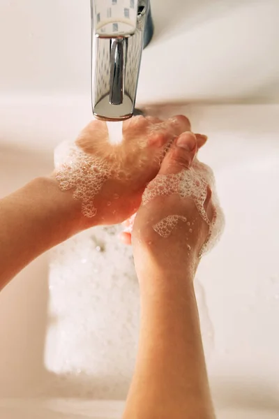 少女はコロナウイルスを防ぐために石鹸で手を洗う. — ストック写真
