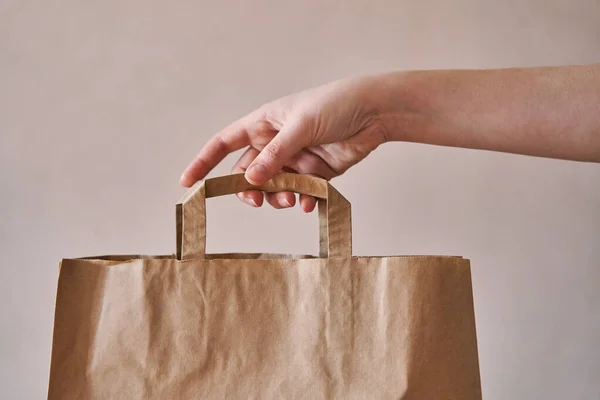 Girl holds an eco-friendly paper bag. Close-up