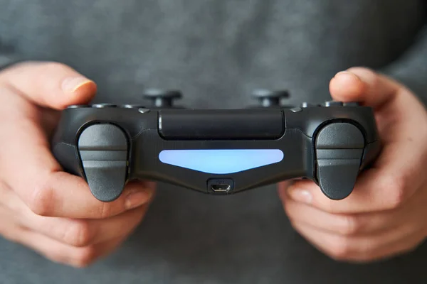 Kaliningrado, Rússia - 14 de abril de 2020: Joystick para consola de jogos. A menina joga no console. Close-up . — Fotografia de Stock