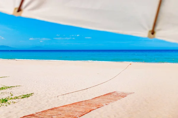 Boş beyaz kumsal ve güneş şemsiyesi, mavi gökyüzü — Stok fotoğraf