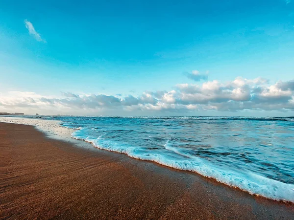 Морской пейзаж, вид на море. Волны в море, прилив, песчаный берег. Облака в небе . — стоковое фото