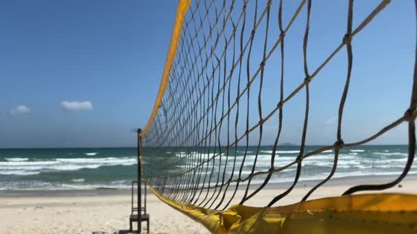 海の近くの砂浜の海岸沿いのビーチバレーコート 現場には誰もいない海の景色 海の波 晴れた日 風の強い天気 澄んだ青い空 — ストック動画