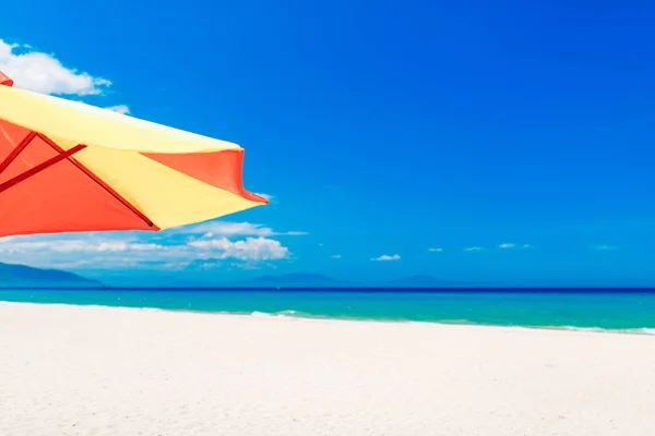 Boş beyaz kumsal ve güneş şemsiyesi, mavi gökyüzü — Stok fotoğraf