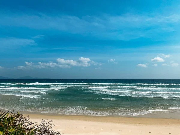 Litoral arenoso, ondas suaves calmas no mar, tempo ensolarado, céu azul — Fotografia de Stock