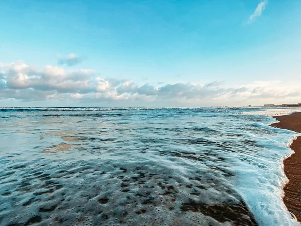 Морской пейзаж, вид на море. Волны в море, прилив, песчаный берег. Облака в небе . — стоковое фото