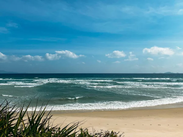 Litoral arenoso, ondas suaves calmas no mar, tempo ensolarado, céu azul — Fotografia de Stock