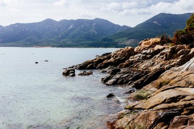 Dağın tepesinden deniz manzarasının panoramik görüntüsü. Mavi deniz, arka planda yeşillikle kaplı tepeler, ufukta görünen adalar. Asya 'da seyahat eden güzel bir manzara.