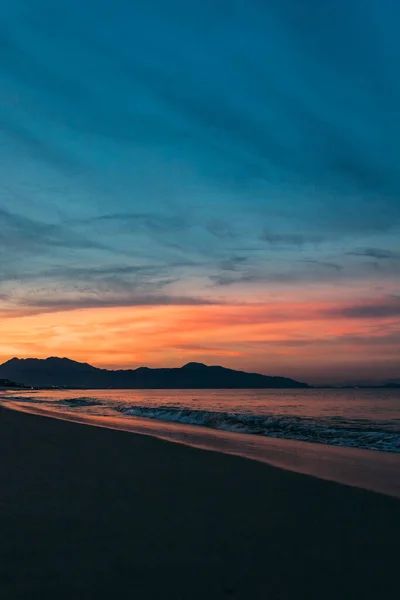 美しい日の出 雲の中の太陽の日没 雲の中の太陽の光 小さな波のある砂浜 海の近くの熱帯地域での暖かい朝の光 — ストック写真