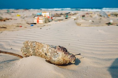 Plastik şişeler ve kumlu deniz kıyısına atılan diğer çöpler, deniz sahilindeki çöpler. Ekolojik bir sorun. Çevre kirliliği. Kirli kumsal.