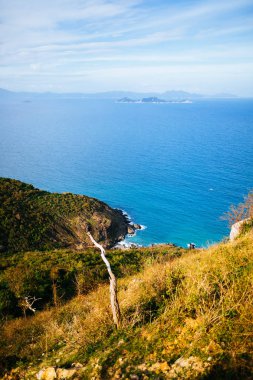 Dağın tepesinden deniz manzarasının panoramik görüntüsü. Mavi deniz, arka planda yeşillikle kaplı tepeler, ufukta görünen adalar. Asya 'da seyahat eden güzel bir manzara.