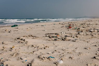 Plastik şişeler ve kumlu deniz kıyısına atılan diğer çöpler, deniz sahilindeki çöpler. Ekolojik bir sorun. Çevre kirliliği. Kirli kumsal.