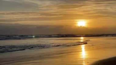 Denizde şafak, sahilde sabah, turuncu şafak. Kumlu bir tropik sahilde dalgalar