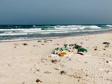Plastik şişeler ve kumlu deniz kıyısına atılan diğer çöpler, deniz sahilindeki çöpler. Ekolojik bir sorun. Çevre kirliliği. Kirli kumsal.