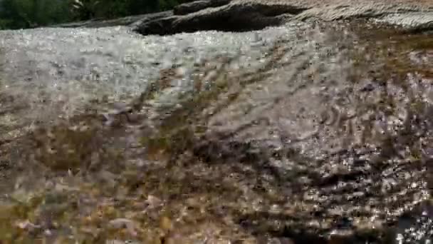 Um córrego da montanha flui através das pedras grandes, espuma do fluxo da água — Vídeo de Stock