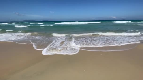 青い海と青い空の背景を持つ空の砂のビーチ。海の波 — ストック動画