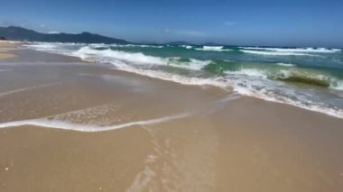 Mavi deniz ve mavi gökyüzü arkaplanlı boş kumsal. Denizde dalgalar