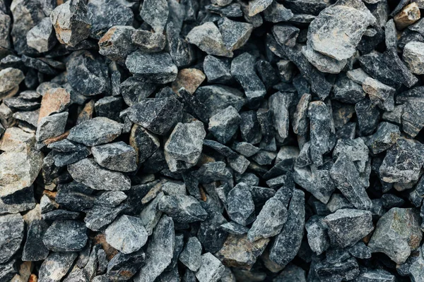 Rough stones, crushed stone, granite gravel close-up. The rough texture of the stone. Building material background. Texture