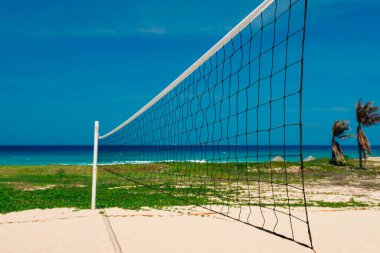 Deniz kenarındaki kumlu sahilde voleybol sahası. Bölgede kimse yok. Deniz manzaralı, güneşli bir gün. Güzel deniz manzaralı, arka planda hindistan cevizi palmiyeleri olan açık hava aktiviteleri için harika bir yer. kopyalama yeri