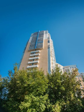 Modern bir gökdelenin güzel manzarası ve manzarası ve yüksek bir bina, balkonları ve loggiaları olan, camdan ve betondan yapılmış bir bina..