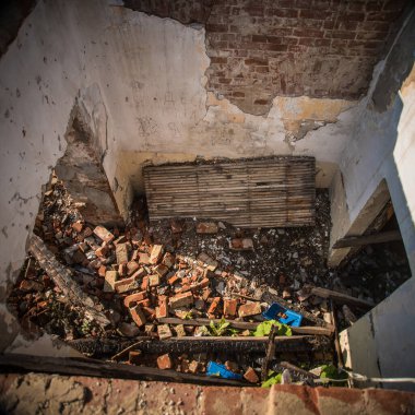 Tahta ve taştan yapılmış, yıkıma hazır ve yıkıma hazır güzel bir yapı, çöp ve çöp manzarası..