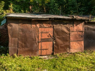 Yazın öğleden sonra, yaprakların arasında eski metal garajın güzel manzarası..