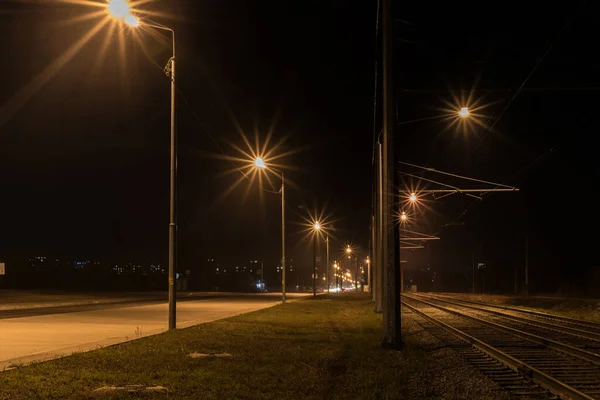 Beautiful road, street, avenue at night in the city with illumination, lights of lanterns, lamps.