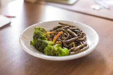 Güzel ve ağız sulandırıcı bir tabak, çeşitli eğreltiotu ve lahana, beyaz bir tabakta servis ve mutfak.