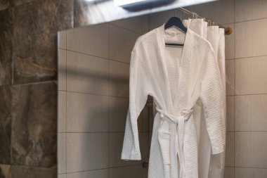 Lüks ve pahalı bir banyonun içinde beyaz pahalı bir bornoz ve pijama..