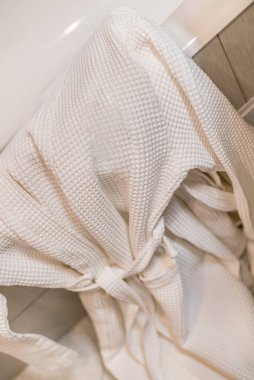 Lüks ve pahalı bir banyonun içinde beyaz pahalı bir bornoz ve pijama..