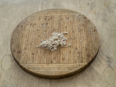 Ahşap tahta kesme tahtası ve tahta bir masanın üzerinde duran ekmek kırıntıları..