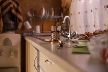 Mutfak, mutfak masası ve bardak tutacağı olan ayakta duran bir bardak..