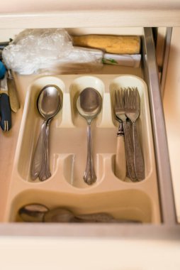 Mutfak dolabındaki çekmecede çatal bıçak, çatal bıçak ve kaşık var..