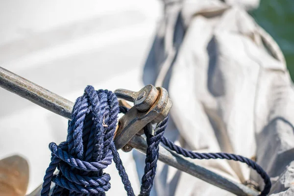 Beautiful view of a small rusty anchor on a light deck on a sunny summer day.