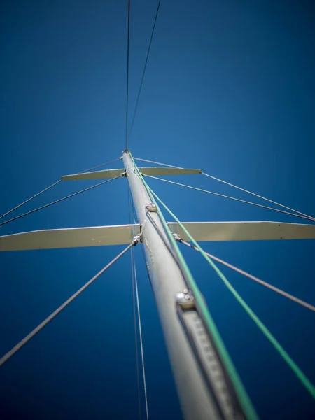 Beautiful view of the mast of the yacht, rigging, rigging against the blue sky on a sunny summer day.