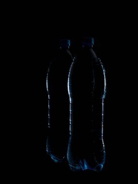 Temiz içme suyu için iki büyük plastik şişenin güzel mavi ana hatları ya da siyah arka planda ferahlatıcı bir içecek..
