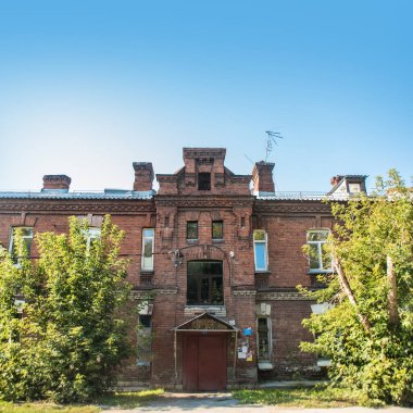 Novosibirsk, Rusya - 17 Eylül 2019. Yazın öğleden sonra öğleden sonra kırmızı tuğladan yapılmış eski tuğlalı bir binanın güzel manzarası ve manzarası..