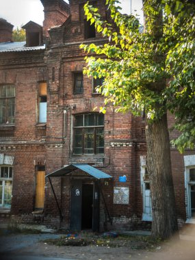 Novosibirsk, Rusya - 17 Eylül 2019. Yazın öğleden sonra öğleden sonra kırmızı tuğladan yapılmış eski tuğlalı bir binanın güzel manzarası ve manzarası..