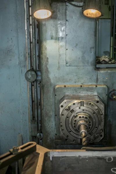 Industrial landscape at the factory, view of the bed, spindle and drill with a lathe shaft.